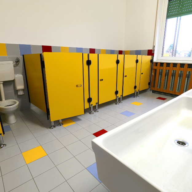 Technician using non-toxic, Ministry of Education-approved products to clean classroom surfaces and restrooms—supporting a safe learning environment.