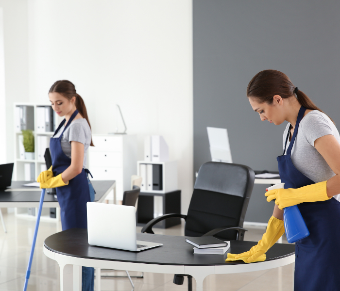 Technician wiping down classroom desks and vacuuming hallways—providing scheduled cleaning for educational facilities across Waikato.